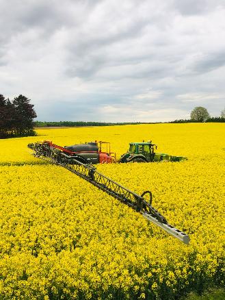 green tractor on yellow flower field during daytime